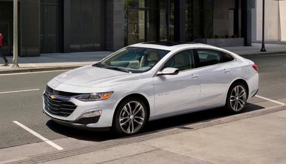 A GM Envolve fleet vehicle parked alone outside a building.