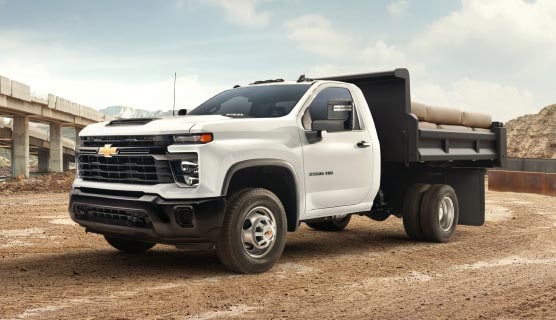 A GM Envolve fleet truck parked alone near a construction area.