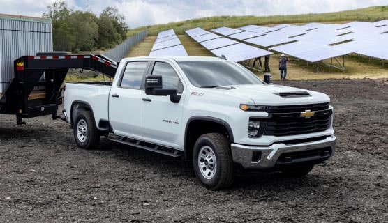 A GM Envolve fleet vehicle parked alone outside near solar panels.