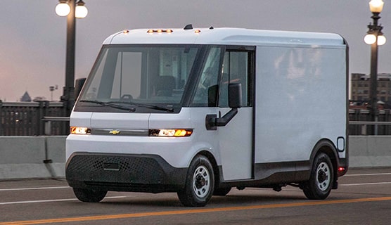 A Chevrolet BrightDrop EV driving alone on a bridge.