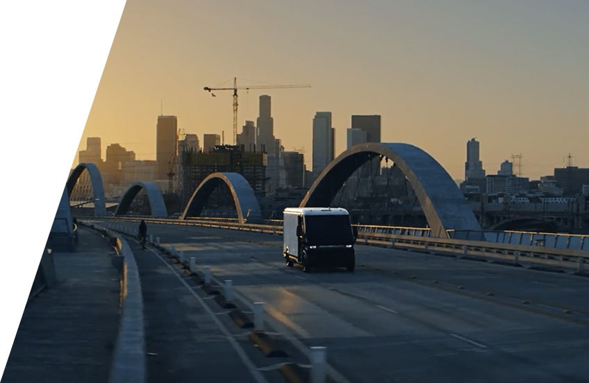 A GM Envolve vehicle driving alone on a bridge during sunset.