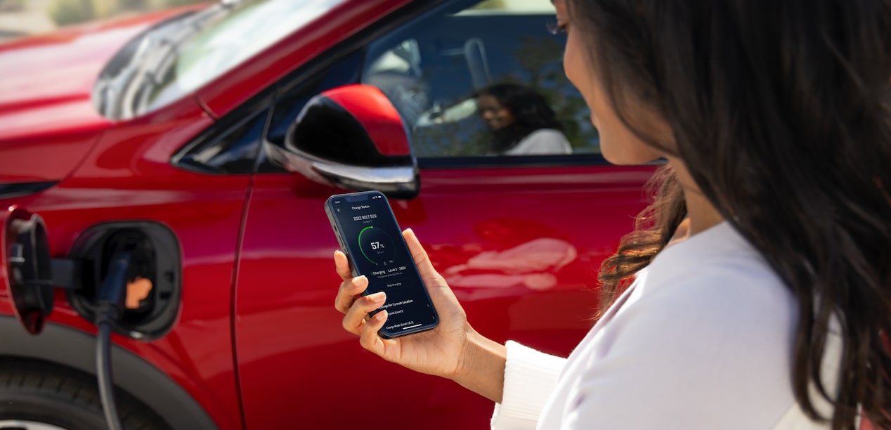 Une femme vérifie le pourcentage de charge d’un Chevrolet Equinox EV 2024 sur son appli.