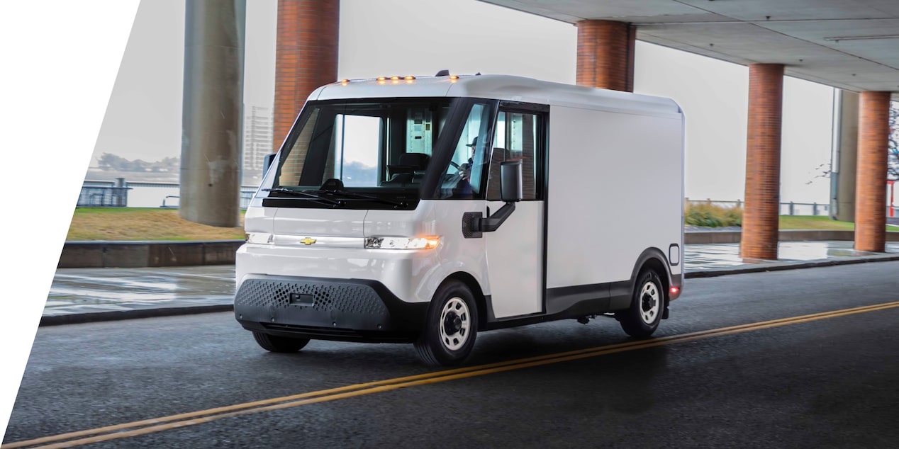 Front-side view of the 2025 Chevrolet BrightDrop EV van driving alone under a shade.