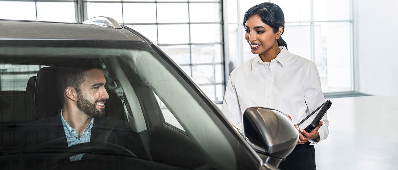 A GM Fleet dealer touring a client inside a vehicle.