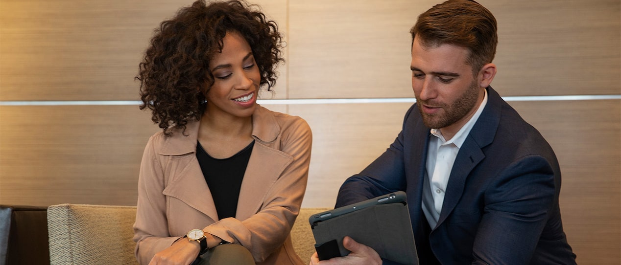 A GM Fleet representative discussing matters to a client using a tablet.