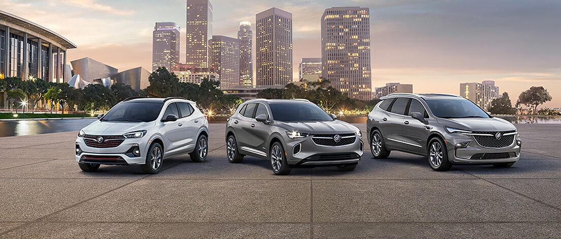 Three GM Fleet vehicles parked on a pavement with cities overlooking behind.