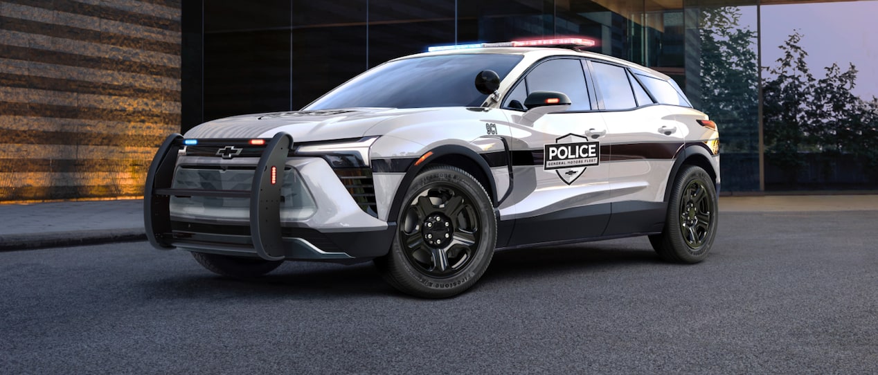 GM Fleet Police Vehicle parked on a pavement outside a building.