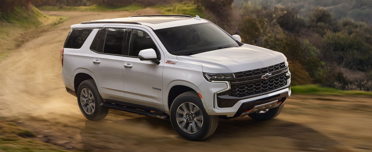 2024 Chevrolet Tahoe driving on a dusty road.