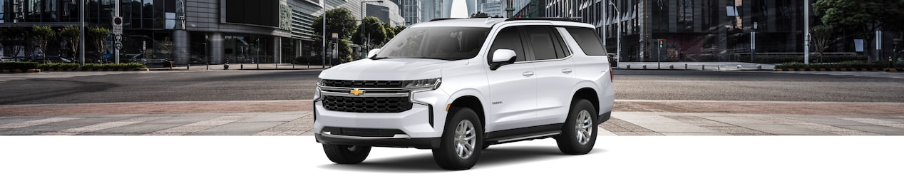 Front-side view of the 2024 Chevrolet Tahoe parked on a city background.