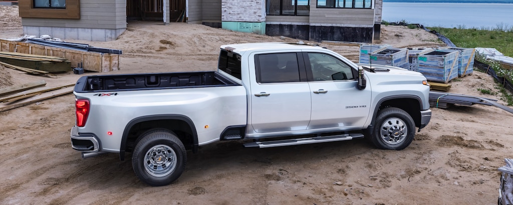 Vue latérale du camion Chevrolet Silverado HD 2024 stationné sur un chantier de construction.