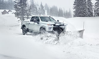 GM Envolve Snow Plow/Spreader Upfit vehicle plowing in a snowy environment.