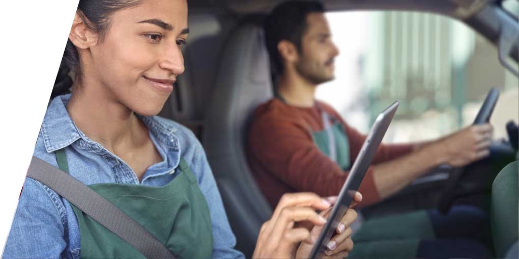 Deux personnes assises dans un véhicule abonné à OnStar et le passager regardant une tablette.