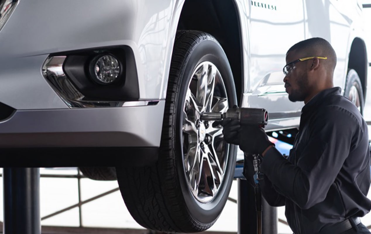 Un technicien du Service Certifié de GM qui travaille sur une roue.