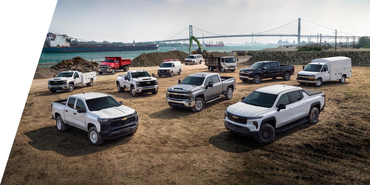 A group of 11 Chevrolet vehicles with varying colors/models, all parked on a construction site.