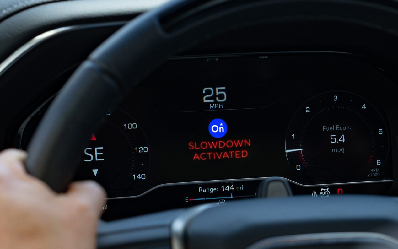 Close-up of OnStar "Slow Down" Feature Activated on a Vehicle's Digital Dashboard