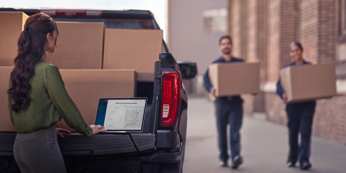 Person working with a laptop in the bed of a truck