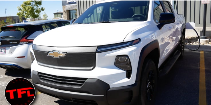 Close Up Front Three-Quarters View of a Chevrolet Silverado EV Plugged Into a Charging Station