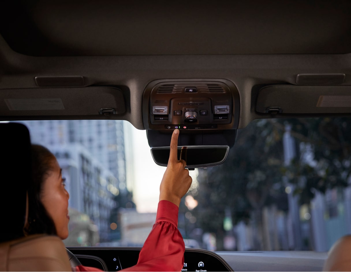 A Driver Pushing the In-Vehicle OnStar Button