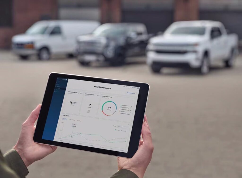 Close-up View of a Person Using a Tablet With Three Trucks in the Background