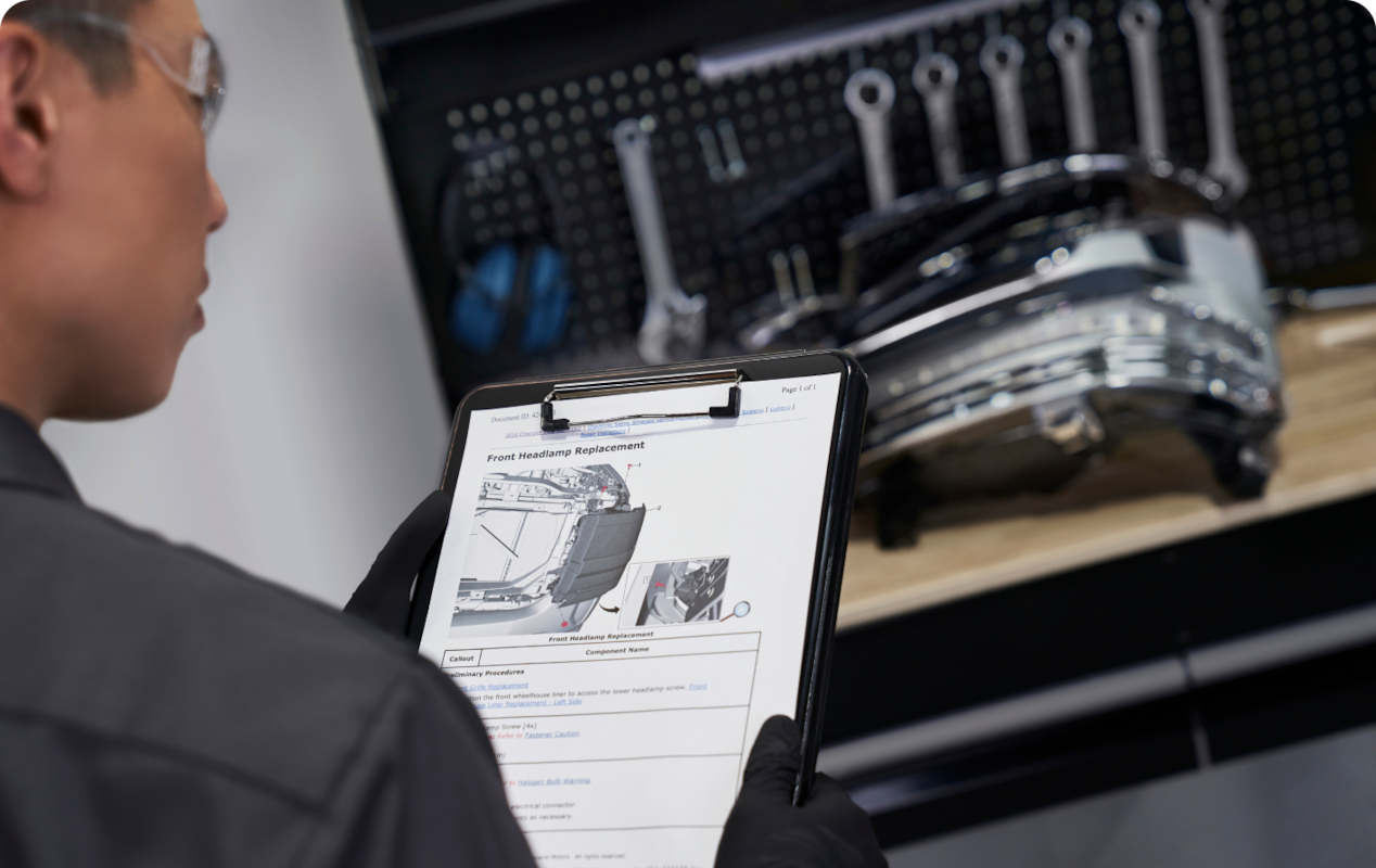 A GM Technician  Reviewing Information on a Clipboard