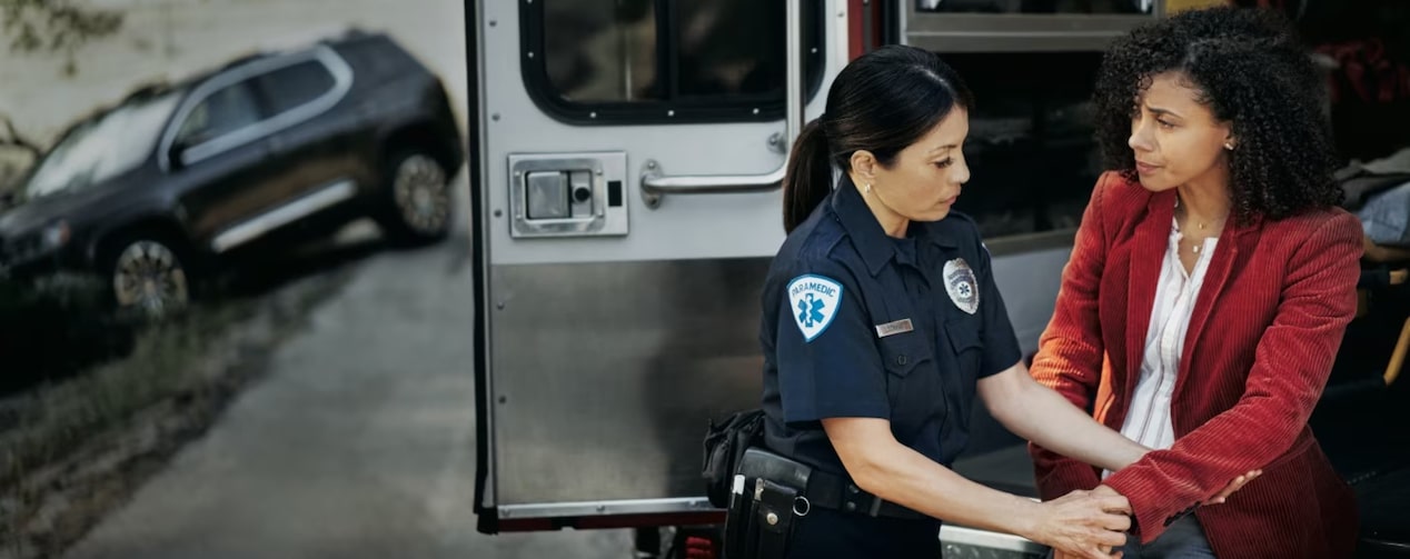 An EMT helping a public safety worker during a road mishap.