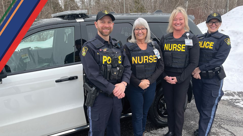 Recipients of the Hero Beyond the Badge award standing outside a vehicle.