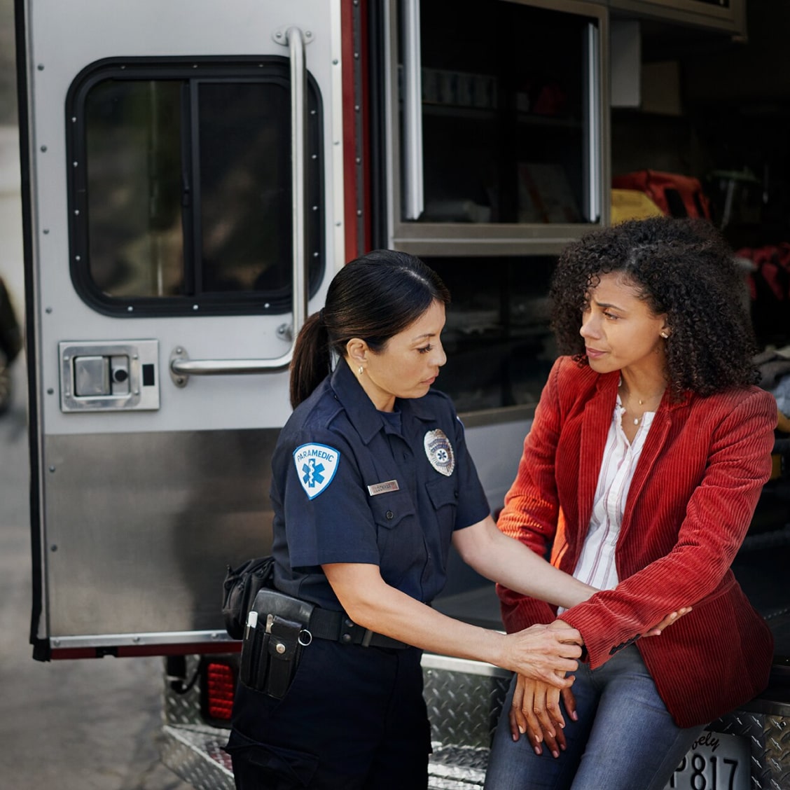 An EMT personnel assisting a public safety worker in a road mishap.