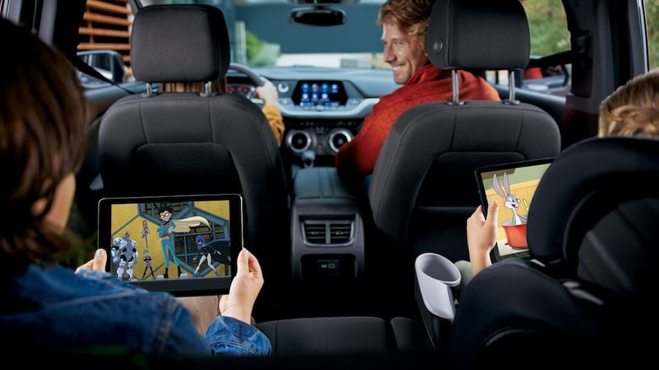 Kids using their gadgets while connected in their vehicle.