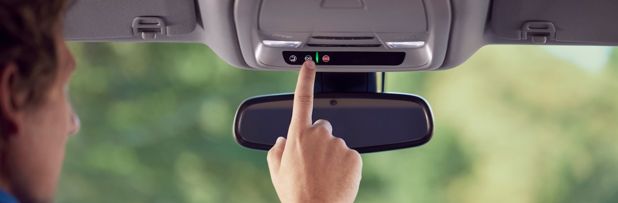 Drivers Hand Reaching for OnStar Blue Button