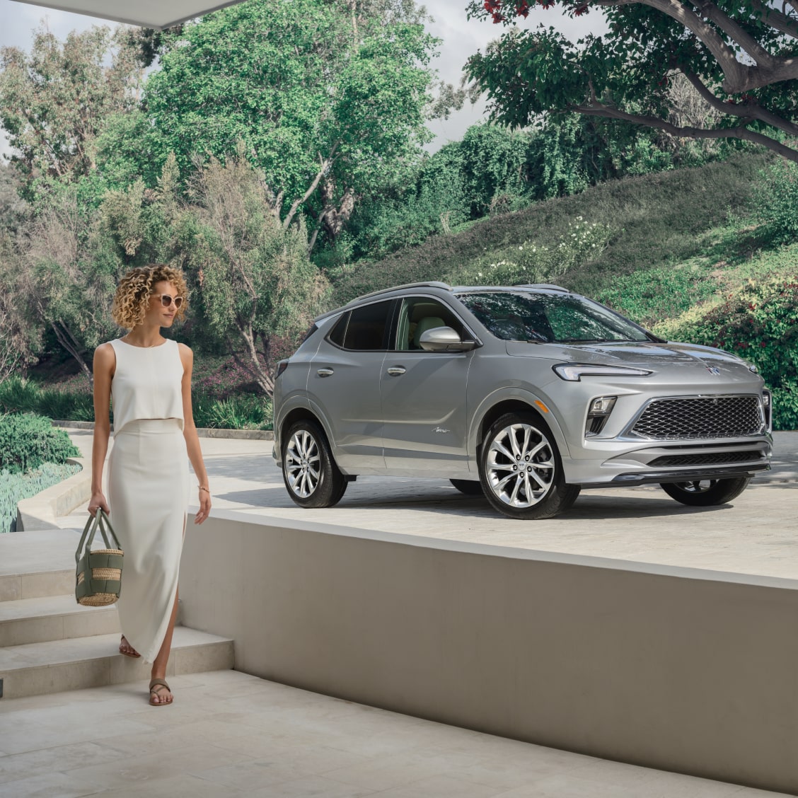 An OnStar-subscribed Buick vehicle parked at a driveway as a person passes by.